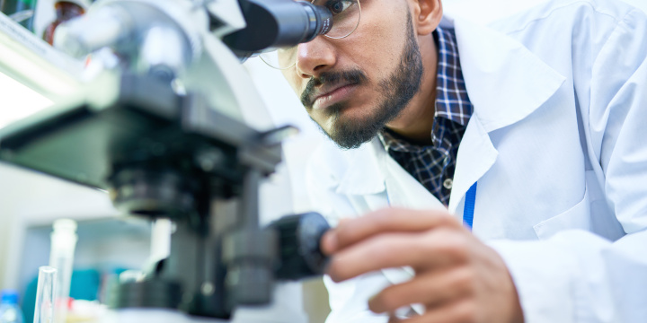 Male scientist at microscope
